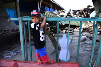 On 4 October 2018 in Indonesia, a young boy, 4 years old, plays in front of the ruins of the building damaged during the earthquake in Palu, South Sulawesi.
 UNICEF/UN0241241/Wilander (CNW Group/UNICEF Canada)