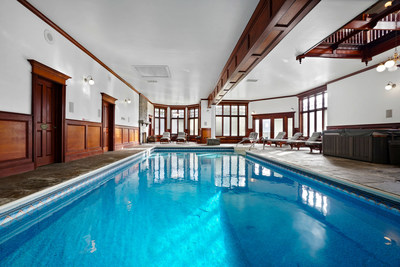 An indoor pool and spa allow for year-round enjoyment, and feature a lounge area complete with a working fireplace. More at NewYorkLuxuryAuction.com.