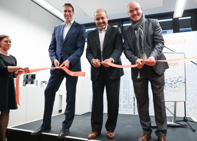 Visteon President and CEO Sachin Lawande (center) cuts a ribbon inside the company's new technology center in Karlsruhe, Germany, flanked by Jens Tillner (left) and Jochen Ladwig, managing directors of Visteon Electronics Germany GmbH.