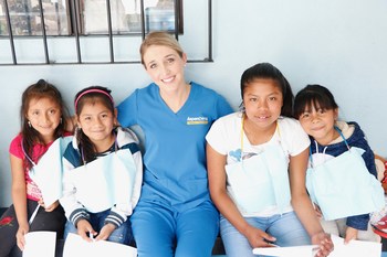 Dr. Savannah Reynolds, Aspen Dental practice owner in Greenville, S.C., takes photos with local kids in Guatemala before providing dental care.