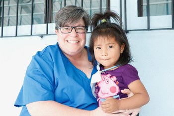 Dental assistant, Tammy Coffey of Aspen Dental-Kentucky shares a special moment with local Guatemalan girl after she received dental care.