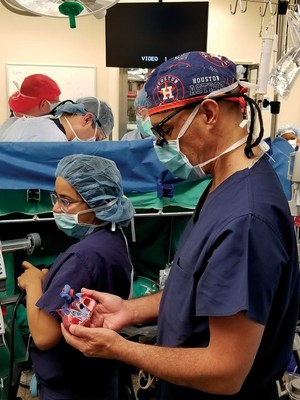 Dr. Salazar references the patient-specific anatomical heart model outside of the sterile field in the operating room.