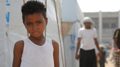 On 4 December 2018 at a camp for internally displaced persons in Aden, Yemen, a child stands outside of their temporary shelter.  UNICEF/UN0262515/Abdulhaleem (CNW Group/UNICEF Canada)