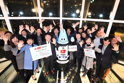 Lota, an AI robot and the first subscriber to KT's 5G network commercial service, cheers with KT officials at the Lotte World Tower on December 1.