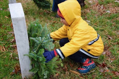 Young child places a wreath at Arlington. Wreaths Across America 2018.