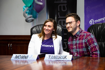Karmel Larson, founder of the new caresharing app Momni, celebrates a funding deal of more than $1.75 million with Tamarak Capital Partner Nate McBride. Momni connects moms for high-quality childcare using a sharing-economy model and easy-to-use apps for both Android and iOS. The funding will help aggressively expand features and open new markets.