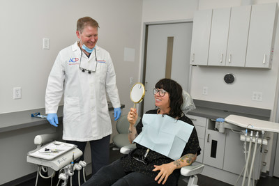 A patient admires the new smile her prosthodontist skillfully crafted by utilizing the latest dental technology and the highest standards of patient care.