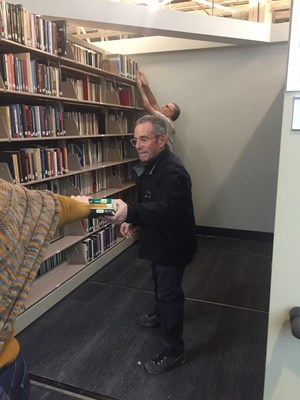 United Theological Seminary of the Twin Cities president Lew Zeidner helps move books into the new library.