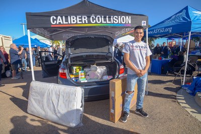 Lance Corporal Alvaro Serna poses with his new car, which was donated by Farmers Insurance and Caliber Collision as part of the NABC Recycled Rides program. Caliber Collision also surprised the Marine by "stuffing the trunk" with gifts for him and his family.