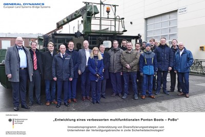 General Dynamics European Land Systems employees in Germany pose in front of the "PoBo" multifunctional, modular floating platform, designed to assist with civil protection and disaster release.