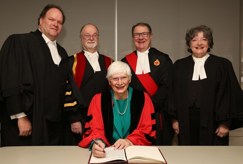 Angela Swan (seated) received an honorary LLD from the Law Society of Ontario (LSO) on January 25, 2019, at its Call to the Bar ceremony in Toronto. Here, she signs the LLD Registry. From left to right: LSO Bencher William McDowell; LSO Treasurer Malcolm Mercer; The Honourable Geoffrey Morawetz, Senior Judge, Toronto Region, Superior Court of Justice; and Treasurer Emeritus Janet Minor. (CNW Group/The Law Society of Ontario)