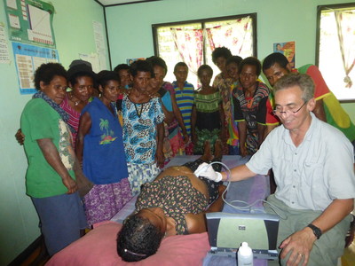 Dr. Rob Liddell demonstrates the use of a portable ultrasound machine and discusses fetal development with local volunteer midwives in Sapmanga village, YUS