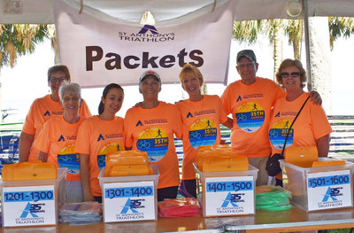 Volunteers at the 2018 St. Anthony’s Triathlon distribute packets to participants.