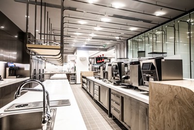 The beverage preparation area features a variety of coffee machines and spacious counters