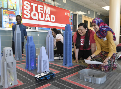 Kim Gonzales, second from right, of Texas Instruments' STEM Squad, and Khudaijah Amin, a Parkville Middle School seventh-grader, program a robotic car with the new TI-Nspire CX II graphing calculator on Wednesday, March 6, 2019 in Baltimore. TI's STEM Squad is traveling the country getting students excited students about math, science and engineering. (Steve Ruark/AP Images for Texas Instruments)