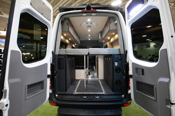 The rear view of the GearHauler garage and the DreamWeaver murphy bed and workbench system in the all new Storyteller Overland MODE 4x4 Adventure Van Series shown here on the Mercedes-Benz Sprinter platform.