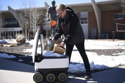 A Starship robot delivers breakfast to a Northern Arizona University student.