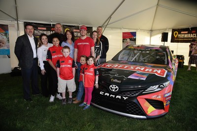 The honorary kids crew proudly stands with the car they helped design.