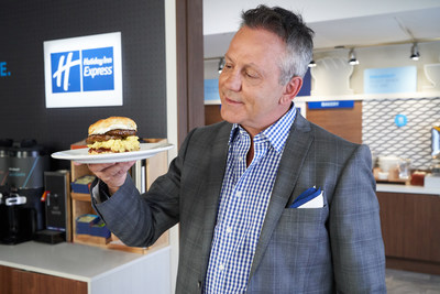 Doug Gilmour with “The Gloves Off Breakfast Sandwich,” a biscuit topped with strawberry jam, a sausage patty, scrambled eggs and cream cheese. (CNW Group/Holiday Inn Express)