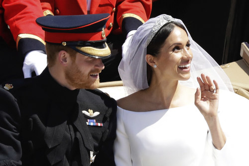 Prince Harry and Meghan Markle react and wave as they leave Windsor Castle in a carriage after their wedding ceremony at St. George's Chapel in Windsor Castle in Windsor, near London, England, Saturday, May 19, 2018. (AP Photo/Matt Dunham)