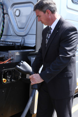 Andrew Cullen, senior vice president of fuels and facilities at Penske Truck Leasing preparing to charge Daimler Trucks North America's electric class 8 Freightliner eCascadia semi-truck.
