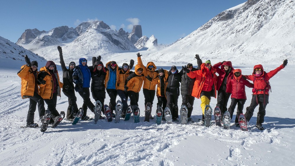 Members of the True Patriot Love Women's Expedition Baffin Island 2019, Presented by Mackenzie Investments, pause for a photo in front of Mount Asgard as they snowshoe 100 km through Auyuittuq National Park (photo credit: Sergeant Shilo Adamson). (CNW Group/True Patriot Love Foundation)