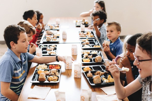 Picture of a table of kids eating lunch at school 
