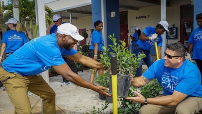 During the 2019 Comcast Cares Day at Forest Hill Elementary School in West Palm Beach, Assistant Principal Sean Higgins works with Principal Scott McNichols to plant new shrubs.