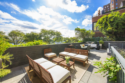 An incredible, waterfront terrace offers two levels and nearly 1,500 sf of outdoor living space. The upper level offers lounge seating and a dining area set against beautiful views of the East River. NewYorkLuxuryAuction.com.