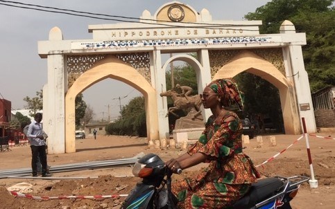 Woman on scooter outside Bamako Hippodrome / photo Rachel Pulfer / JHR (CNW Group/Journalists for Human Rights (JHR))