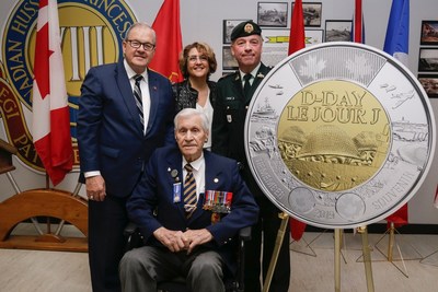 The unveiling of the $2 circulation coin commemorating the 75th anniversary of D-Day at the Moncton Garrison (May 27, 2019).  From left: Veterans Affairs Minister Lawrence MacAulay, Royal Canadian Mint CEO Marie Lemay, North Shore Regiment Commander LCol Rnald Dufour and D-Day veteran Alphonse Vautour (seated). (CNW Group/Royal Canadian Mint)