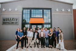 USBG 2019 World Class finalists in front of the soon-to-open Bulleit Distilling Co. Visitor Experience (left to right) back row: Rebecca Edwards, Katie Renshaw, Adam Fournier, Joshua Haddock, James DeFrance. Front row: Samuel Penton, Henry Whittaker, Kevin King, Lauren Paylor, Slava Borisov, Jason Seele, Leanne Favre, Patrick Abalos, Nic Wallace, Christina Mercado