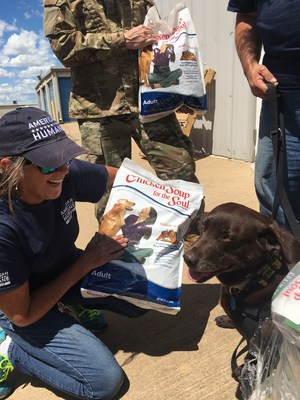 American Humane veterinarian Lesa Staubus DVM and service dog Chili react gratefully to a donation of 3,210 pounds of love and support from Chicken Soup for the Soul Pet Food to American Humane's 