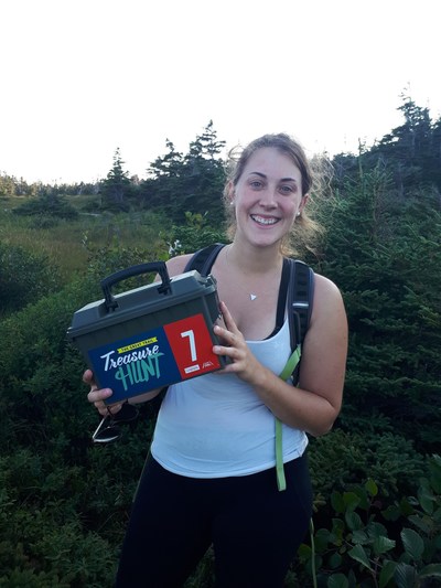 Sarah Pitcher finds a box on the Great Trail Treasure Hunt 2018 on the East Coast Trail Newfoundland. (CNW Group/Royal Canadian Geographical Society)