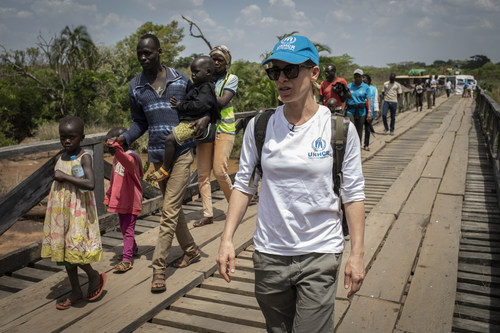 UNHCR supporter Jillian Michaels walks with newly arrived South Sudanese refugees as they cross a wooden bridge on their way to their new settlement in the Democratic Republic of the Congo. ©UNHCR/Siegfried Modola