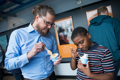 Ben & Jerry's CEO Matthew McCarthy and Rasir Corzen, 11, of Philadelphia, Pa., enjoy ice cream while viewing the newly opened Art for Justice exhibit at the Ben & Jerry's factory on Tuesday, June 25, 2019 in Waterbury, Vt. The exhibit highlights the need for criminal justice reform and features artwork by formerly-incarcerated artists. (Andy Duback/AP Images for Ben & Jerry’s)