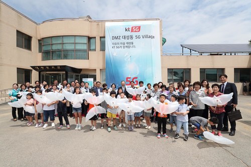 KT executives, including Chairman Hwang Chang-Gyu (center), and residents, elementary school teachers and students are pictured in front of town hall at the opening ceremony of 5G Village in the DMZ’s Daeseong-dong on June 27