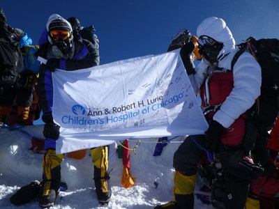 Alexander Pancoe (left) flies the Ann and Robert H. Lurie Children's Hospital Flag at the top of Mt. Everest. The flag features signatures from patients in the pediatric neurology unit at Lurie Children's Hospital. To date, Pancoe has raised $500,000 for pediatric neurology research through his platform, Peaks of Mind. Alexander Pancoe (left) flies the Ann and Robert H. Lurie Children's Hospital Flag at the top of Mt. Everest. The flag features signatures from patients in the pediatric neurology unit at Lurie Children's Hospital. To date, Pancoe has raised $500,000 for pediatric neurology research through his platform, Peaks of Mind.