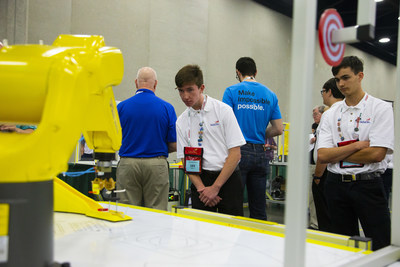 Noah Logan, left, a student at Stafford Technical Center in Rutland, Vermont, watches a FANUC robot arm place on a target the 3D Printed tool he designed with his teammate Matthew Noel, who looks on during the 2019 SkillsUSA Additive Manufacturing Competition.