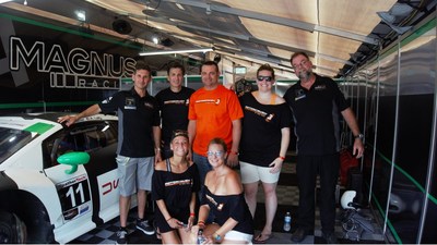 Houston (center) stands with the MotorCrush and Magnus Racing Team, including professional driver, Andy Lally (far left)
