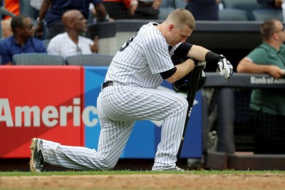 Yankees third baseman Todd Frazier kneels after his foul ball struck a toddler in the face. (Getty Images)