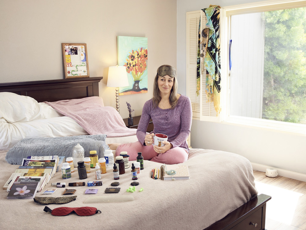 Ginger Soto, 43, surrounded by a variety of her sleep aids. According to survey findings, those who use sleep aids and supplements are less satisfied with their sleep than those who don't.