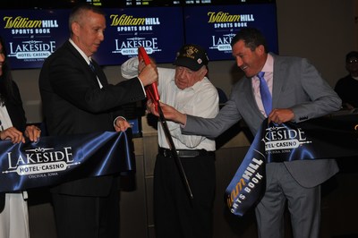 Included in photo: DAVE MONROE, VP & General Manager, Lakeside Hotel & Casino, JOSEPH REYNOLDS, Clark County Resident, WWII Veteran, DAVID GROLMAN, President of U.S. Retail Operations, William Hill