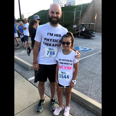 Pressley Atkins, 9, and her Mercy physical therapist, Chris Nichols, finish a 5K run.