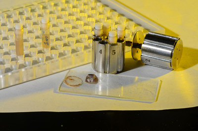 Barnacle samples in pressure cycling technology (PCT) tubes and bullet with barnacle samples in the background are used for proteomics analysis at U.S. Naval Research Laboratory, Washington, D.C. August 2, 2019. The barnacle base plate covers the glue, illustrating how difficult sample collection is; the tubes and bullet are specially designed to handle high pressure conditions. (Navy photo by Jonathan Steffen)