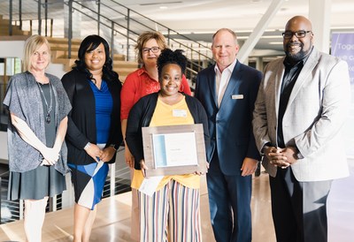 Lake Trust Foundation Community Impact Scholarship recipient LaToya Wright of Muskegon in foreground with (left to right) Lake Trust's Chief Member Experience Officer Jane Kile, Senior Vice President of Culture and Engagement Brandalynn Winchester-Middlebrook, Senior Vice President of Onstage Member Experience Theresa Dubiel, President and CEO David Snodgrass and Lake Trust Foundation Executive Director DeAndre Lipscomb.