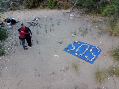 SOS Sign created by Whitson family after dropping their Nalgene water bottle, with SOS message, over the waterfall.