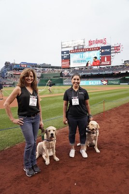 Vice President of PenFed Digital and volunteer puppy raiser, Andrea McCarren, with Canine Companions assistance dog in training Maverick and Emma Phillips, PenFed volunteer puppy raiser and University and Campus Recruitment Lead with Clint are on-field ahead of the Nationals Game as PenFed was recognized for its support and commitment to raising assistance dogs to help veterans and people with disabilities.