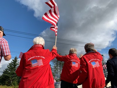 Freeport Flag Ladies - Elaine Greene, JoAnn Miller and Carmen Footer - wave the American flag along with Founder of Wreaths Across America, and Worcester Wreath Co., Morrill Worcester, along Rte. 1 in Columbia Fall, Maine. Each Tuesday moving forward, Wreaths Across America will raise the flag at the new monument there, donated by Worcester Wreath Co., to honor the patriotism and commitment of these dedicated women over the last 18 years.