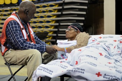 Red Cross Shelter worker, Waymond Hackney, provides comfort to shelter resident, Beverly Coates during Hurricane Barry. Contributions from Annual Disaster Giving Program (ADGP) and Disaster Responder Program members ensure the American Red Cross is prepared to provide help and hope to people affected by disasters like storms and countless other crises. Daniel Cima/American Red Cross. Red Cross Shelter worker, Waymond Hackney, provides comfort to shelter resident, Beverly Coates during Hurricane Barry. Contributions from Annual Disaster Giving Program (ADGP) and Disaster Responder Program members ensure the American Red Cross is prepared to provide help and hope to people affected by disasters like storms and countless other crises. Daniel Cima/American Red Cross.